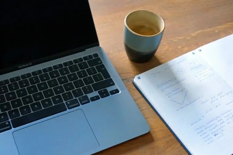 Een afbeelding van een kop koffie, een laptop en een schrijfblok met advies over unieke waarde.