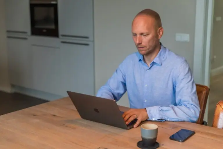 Yuri Dingemans aan het werk op een laptop aan de keukentafel.