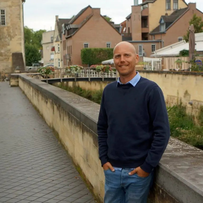 Yuri Dingemans voor een stenen muur in Valkenburg genietend van de rust.