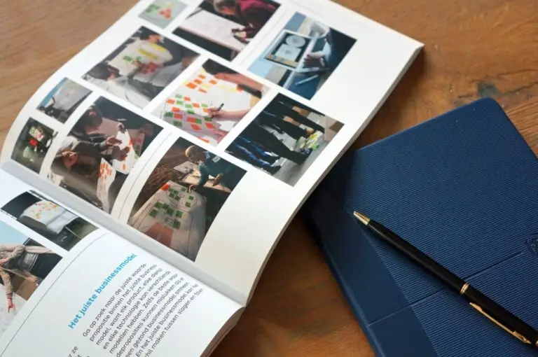 Een schrijfblok, pen en geopend boek over werkvormen voor strategische sessies.